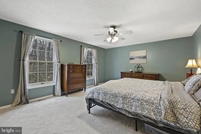 a bedroom with a bed dresser and a window