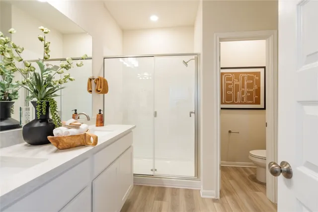 a bathroom with a sink and mirror with shower