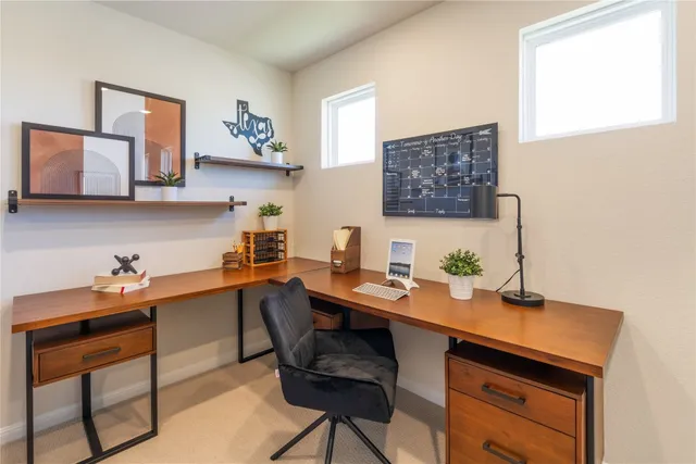 a room with a table chairs and a workspace