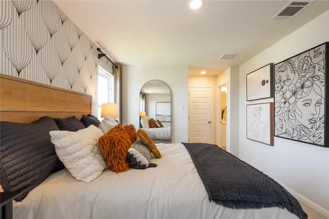 a bedroom with a large bed and a painting on the wall