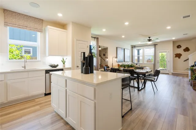 a kitchen with white cabinets and sink