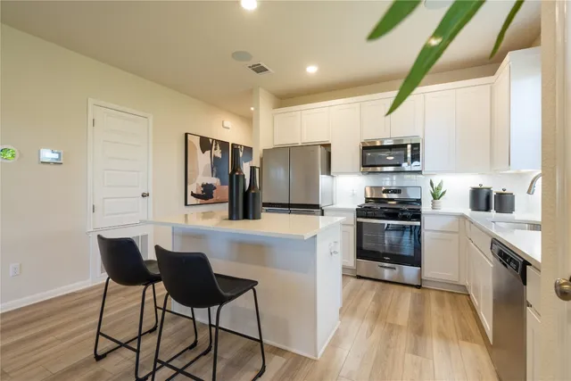 a kitchen with stainless steel appliances a stove refrigerator sink and microwave