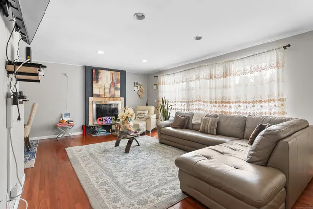a living room with furniture wooden floor and a large window