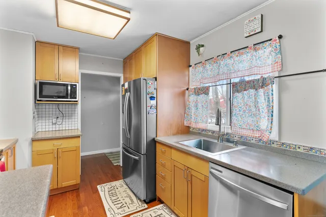 a kitchen with stainless steel appliances a sink stove and refrigerator