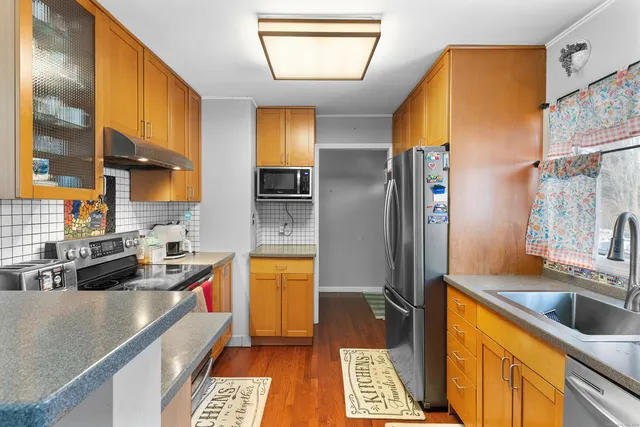 a kitchen with stainless steel appliances granite countertop a sink a stove and a refrigerator