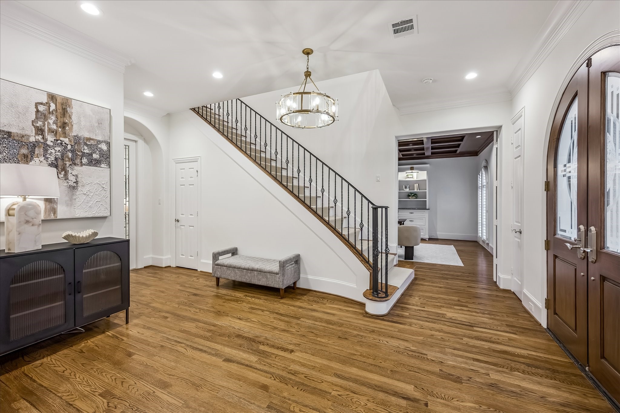 5034 Tangle Lane Houston, TX 77056 - Photo 4 of 50 ENTRY. The gracious entry introduces the home’s refined interior with hardwood flooring, a statement chandelier and arched architectural transitions that lead naturally into the principal living spaces. The entry flooring and chandelier were both updated as part of the renovation.