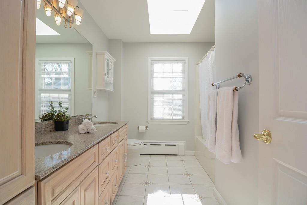 7 Benjamin Road Lexington, MA 02421 - Photo 25 of 42 a bathroom with a granite countertop sink a toilet and bathtub