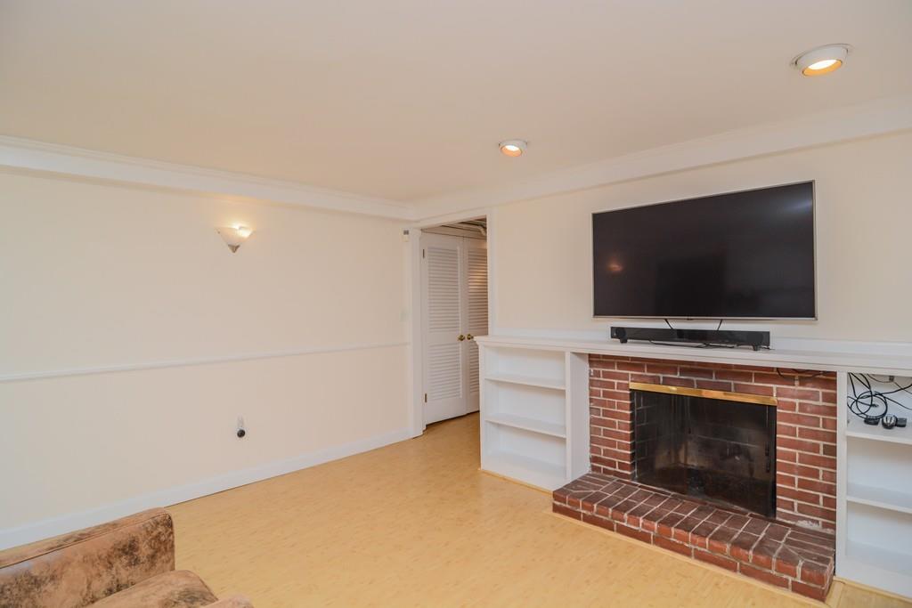 7 Benjamin Road Lexington, MA 02421 - Photo 37 of 42 a living room with a fireplace and a flat screen tv
