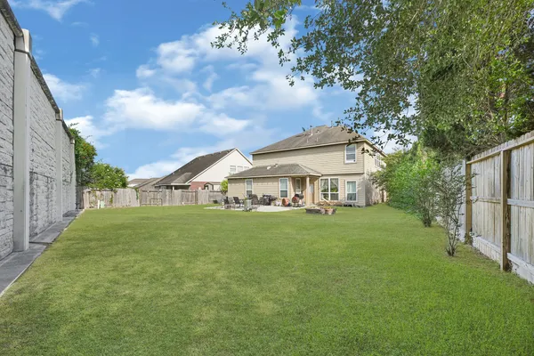 a view of a big house with a big yard plants and large trees