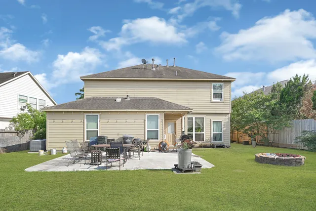 a view of a house with a patio and a yard