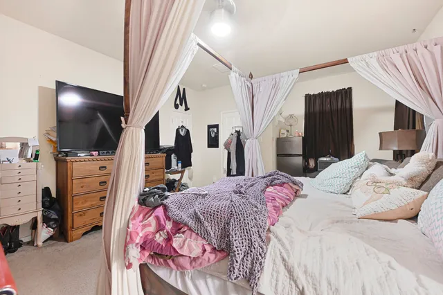 a bedroom with a bed and flat screen tv