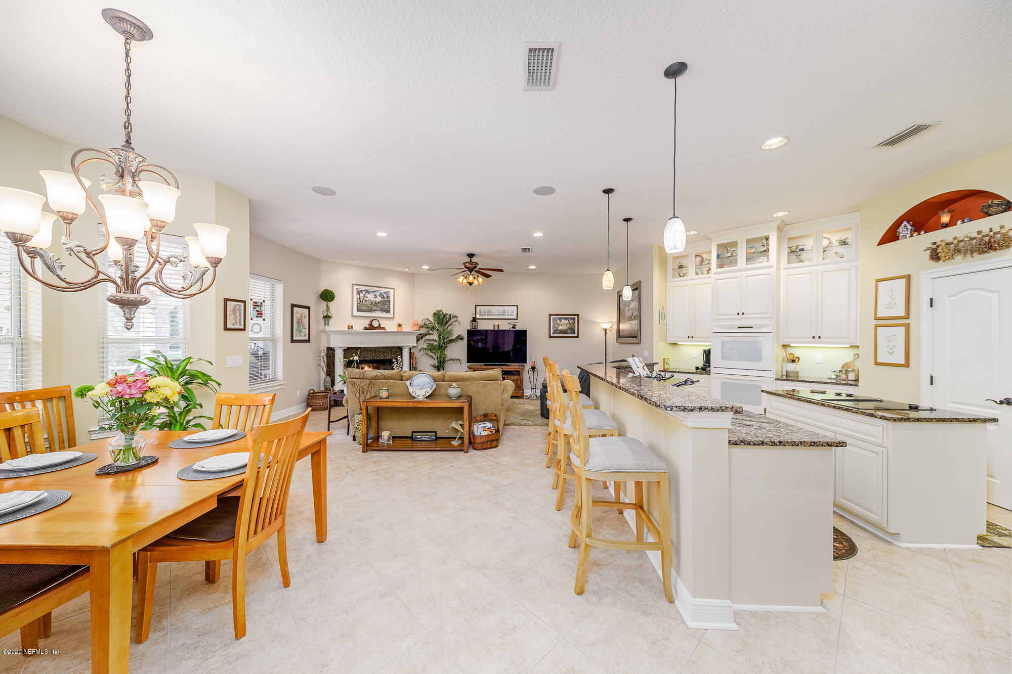8313 Sheila Drive St. Augustine, FL 32092 - Photo 14 of 54 a kitchen with kitchen island a chandelier a sink stainless steel appliances and cabinets