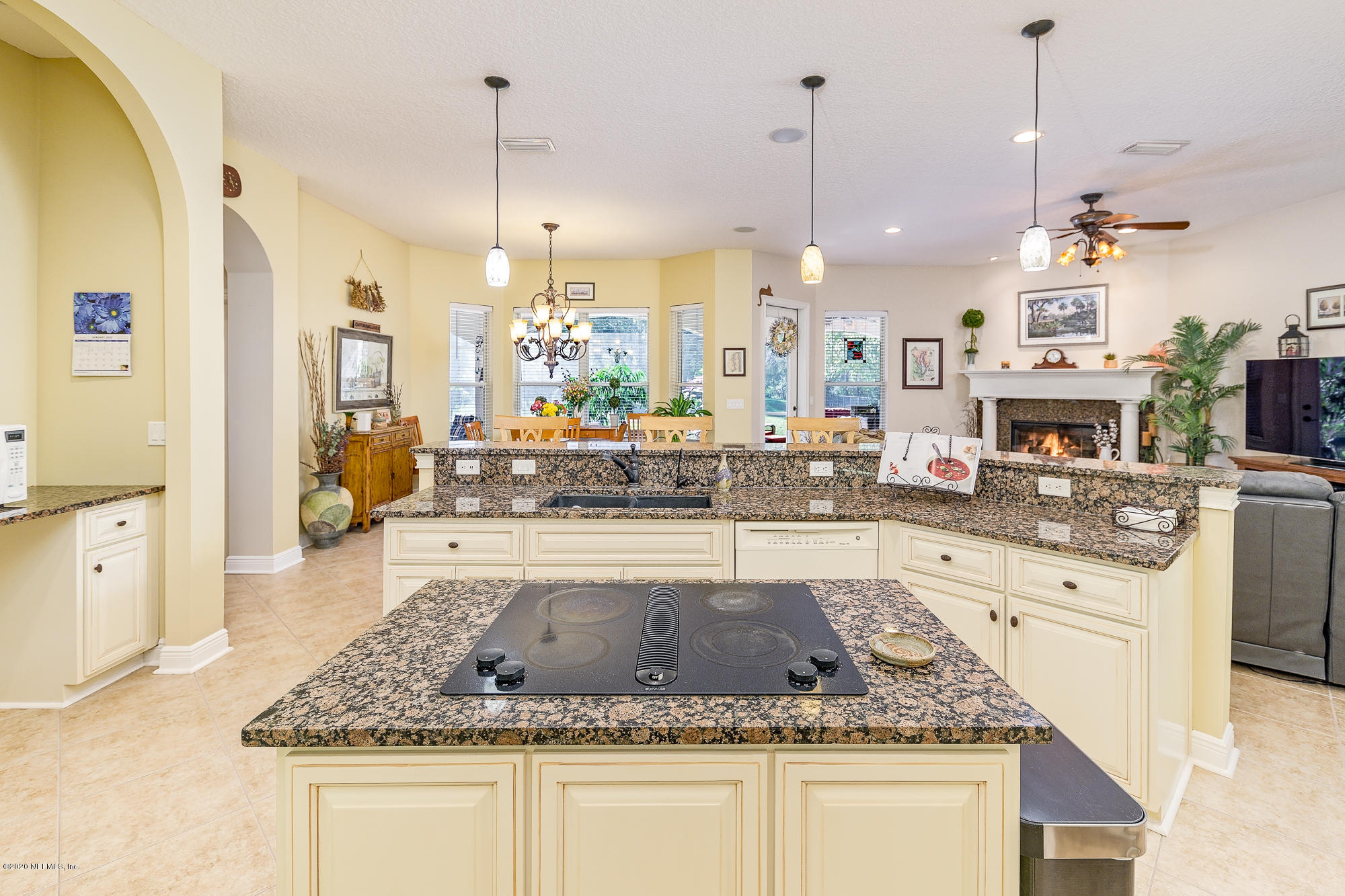 8313 Sheila Drive St. Augustine, FL 32092 - Photo 19 of 54 a kitchen with kitchen island granite countertop a stove a sink a oven and a dining table with wooden floor