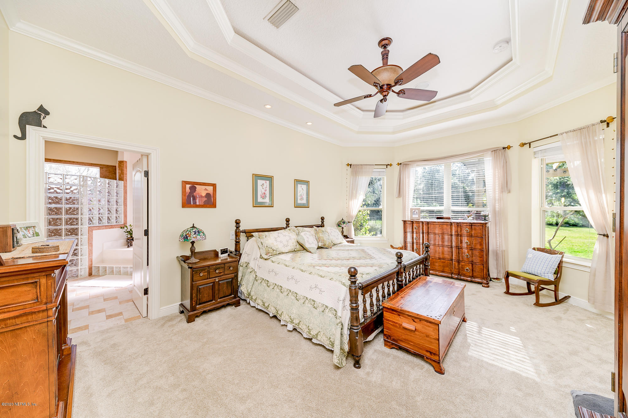 8313 Sheila Drive St. Augustine, FL 32092 - Photo 24 of 54 a spacious bedroom with a bed a table and a chandelier