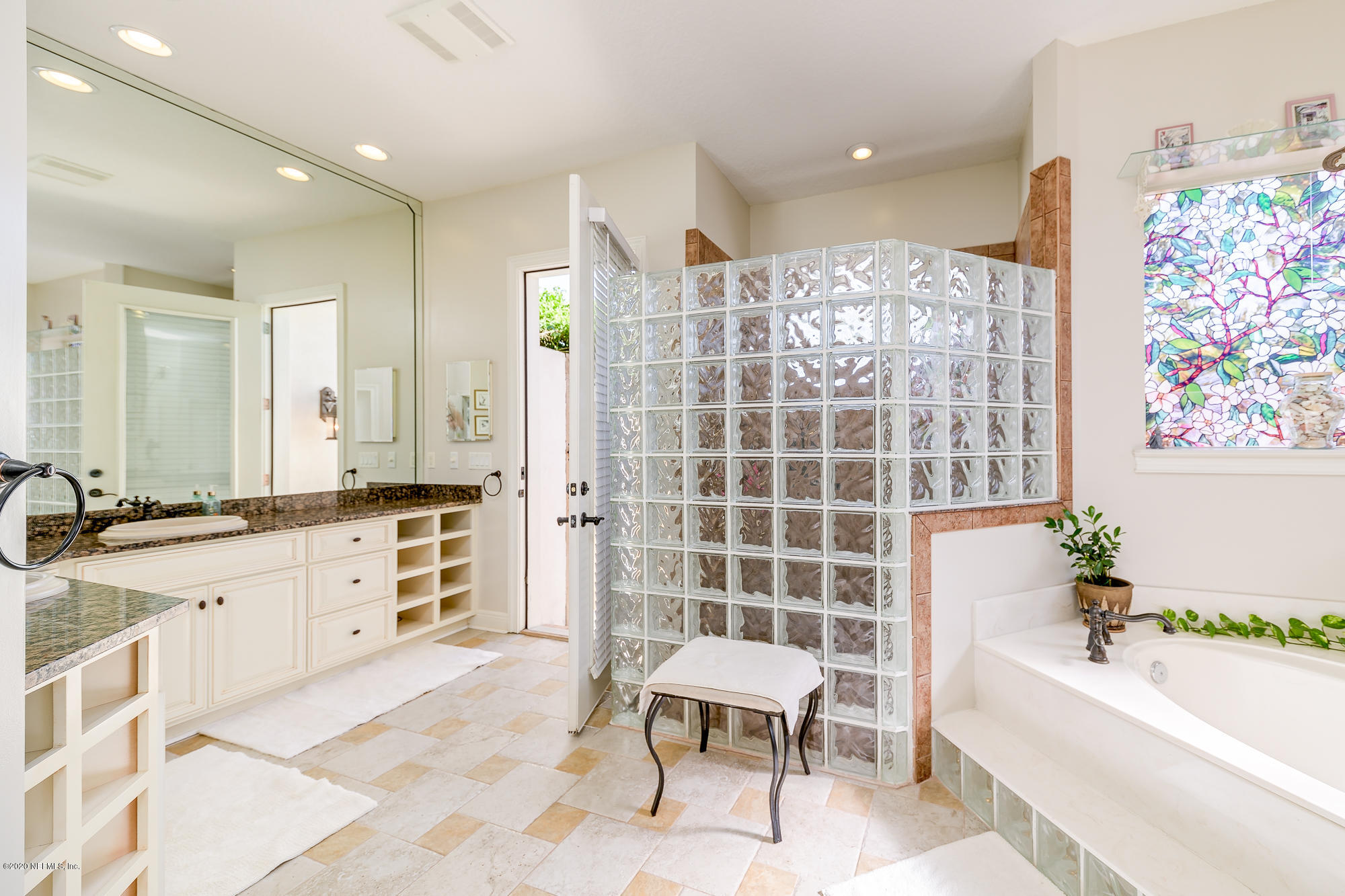8313 Sheila Drive St. Augustine, FL 32092 - Photo 27 of 54 a bathroom with a granite countertop tub sink shower and a mirror