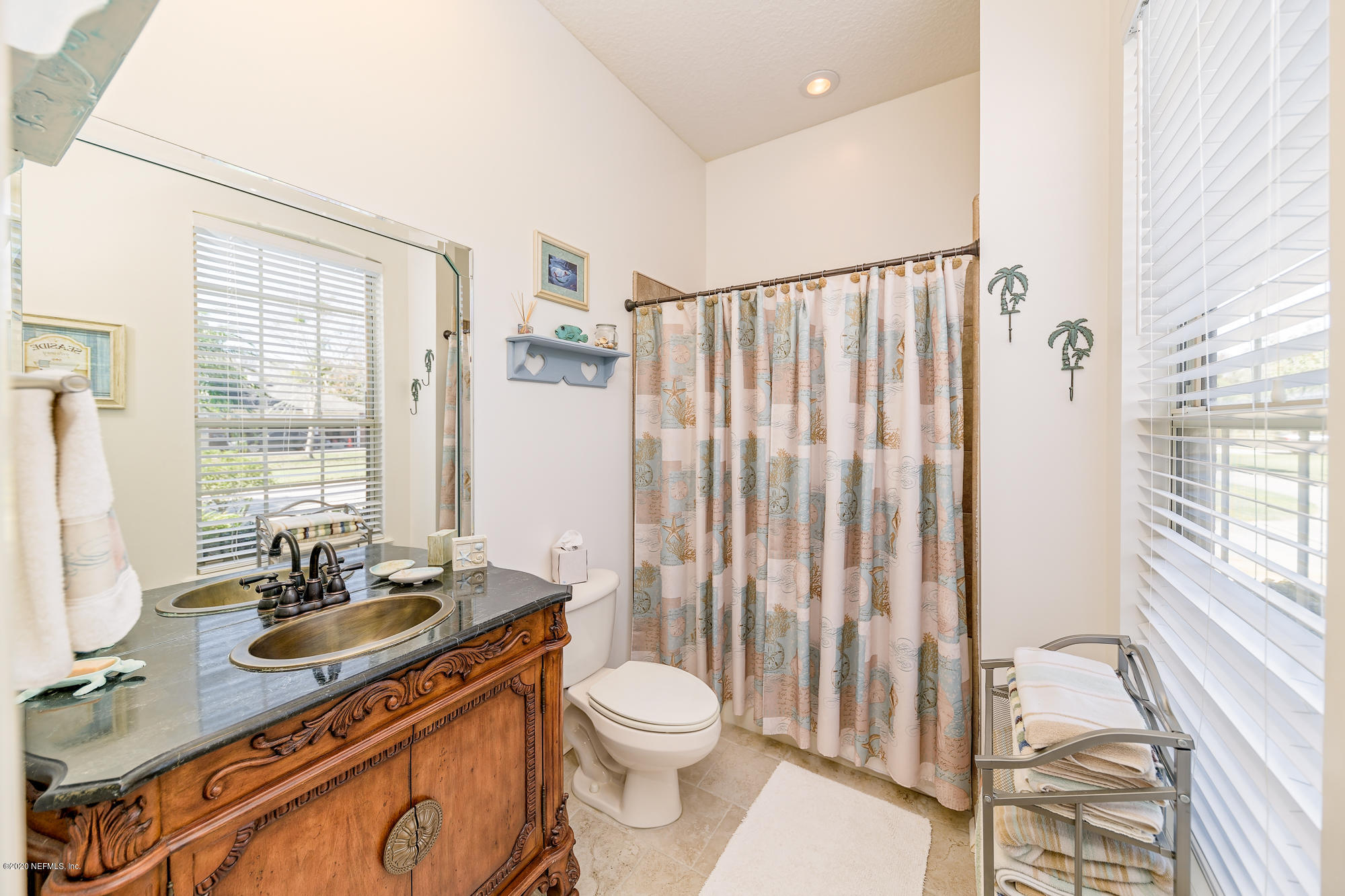 8313 Sheila Drive St. Augustine, FL 32092 - Photo 34 of 54 a bathroom with a granite countertop sink toilet a mirror and shower
