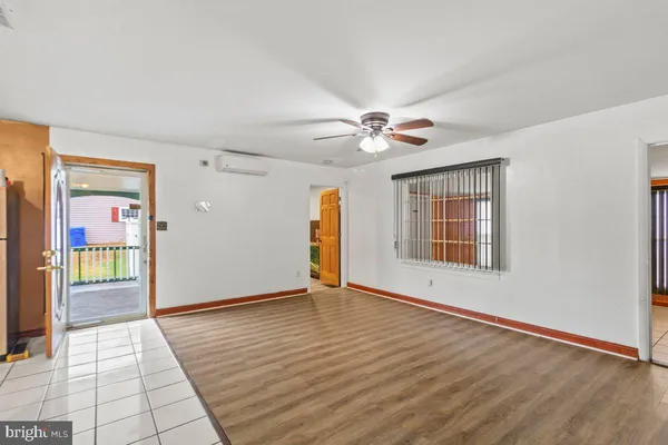 a view of an empty room with window and wooden floor