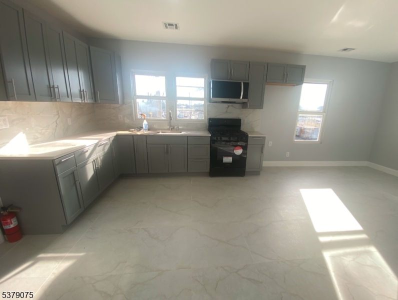 476 Bloy Street Hillside, NJ 07205 - Photo 3 of 5 a kitchen with granite countertop a refrigerator and a stove top oven