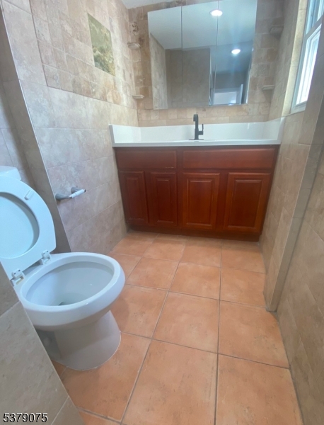 476 Bloy Street Hillside, NJ 07205 - Photo 5 of 5 a bathroom with a sink a toilet and a mirror