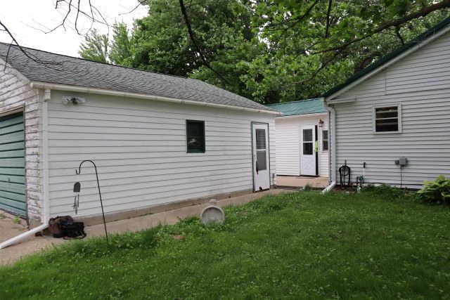 20590 Moline Road Lyndon, IL 61261 - Photo 3 of 11 a backyard of a white house with potted plants and a large tree