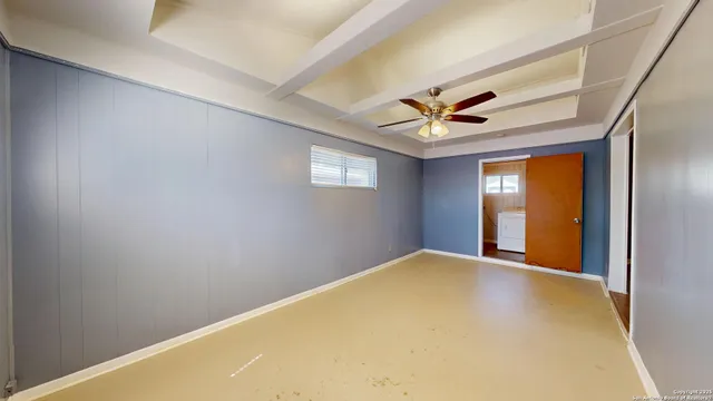 a view of a big room with windows and a ceiling fan