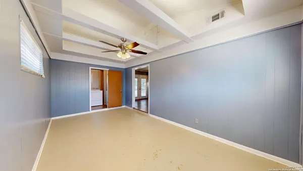 a view of a big room with windows and chandelier fan