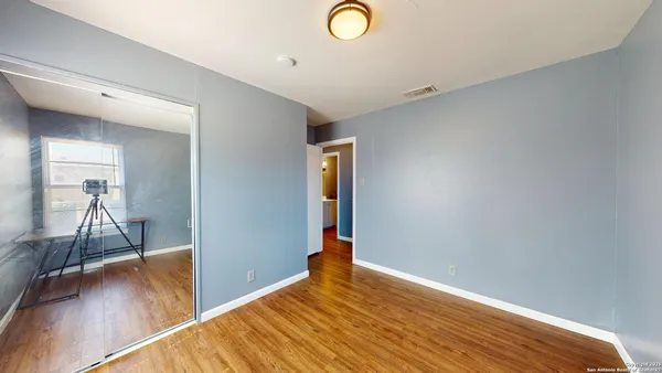 a view of empty room with wooden floor