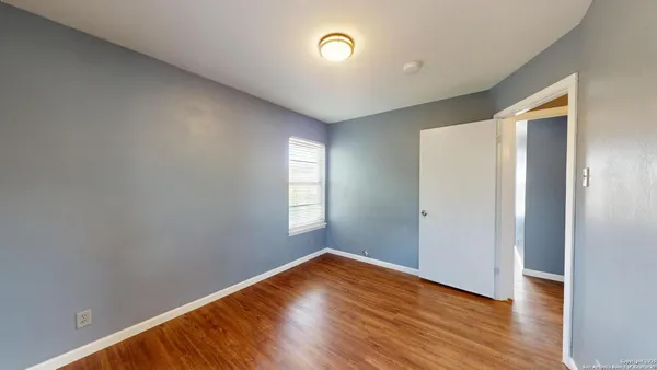 a view of empty room with wooden floor