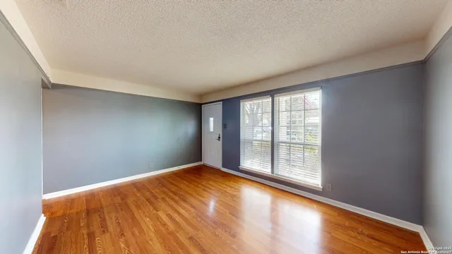 a view of empty room with wooden floor