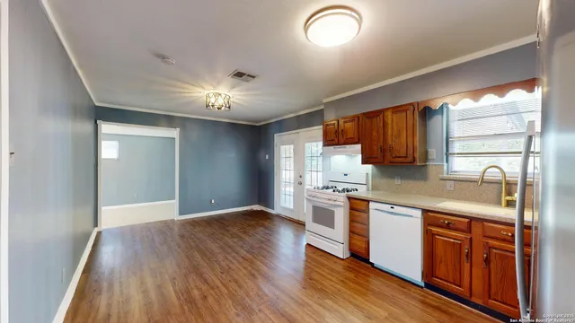 a large kitchen with stainless steel appliances granite countertop a stove and a wooden floors