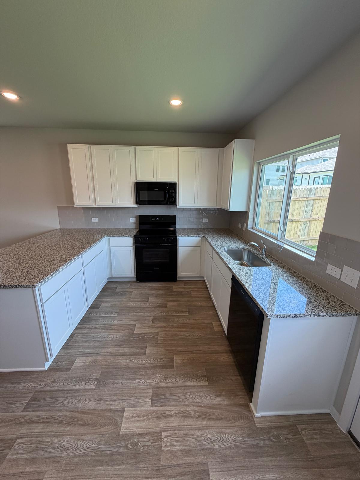 2612 Towy Road Manor, TX 78653 - Photo 26 of 35 A well-lit kitchen featuring resilient flooring and ample counter space for culinary endeavors.