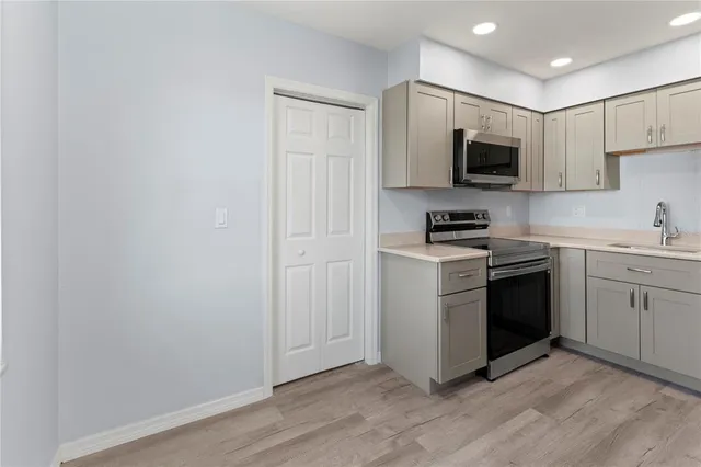 a kitchen with white cabinets stainless steel appliances and sink