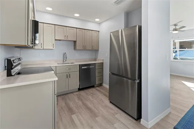 a kitchen with stainless steel appliances granite countertop a refrigerator sink and microwave