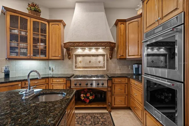 a spacious bedroom with a large bed a chandelier and windows