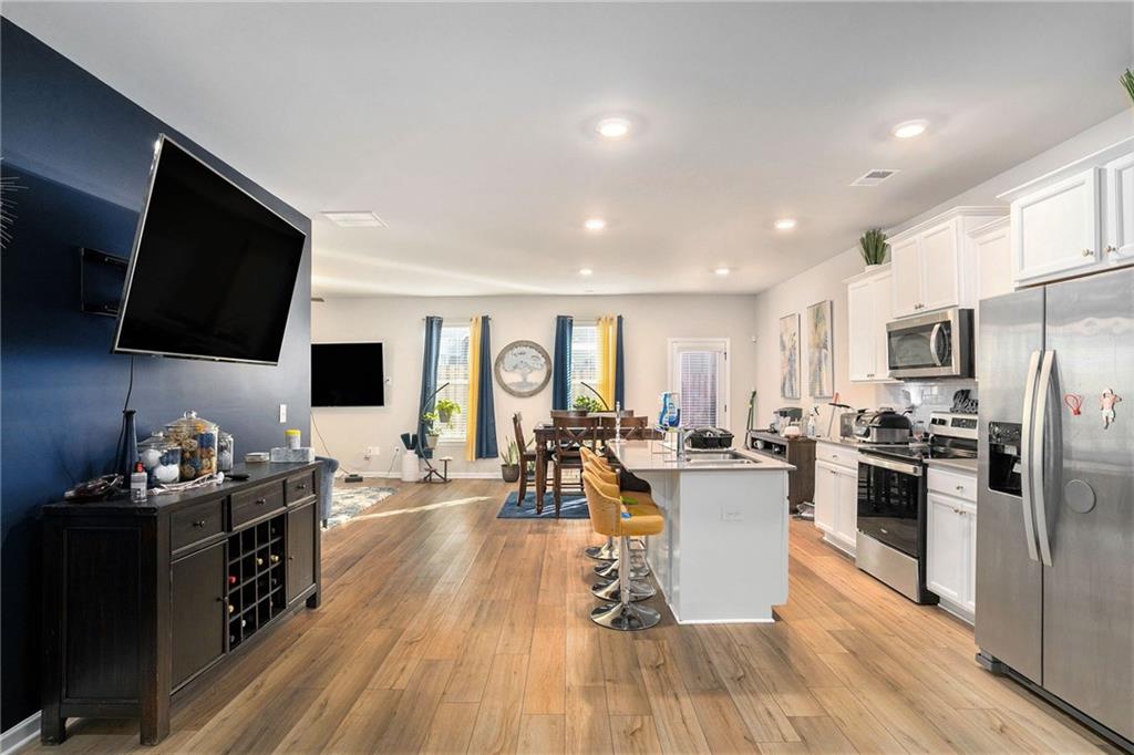 11940 Brightside Parkway Hampton, GA 30228 - Photo 11 of 31 a living room with stainless steel appliances furniture and a flat screen tv