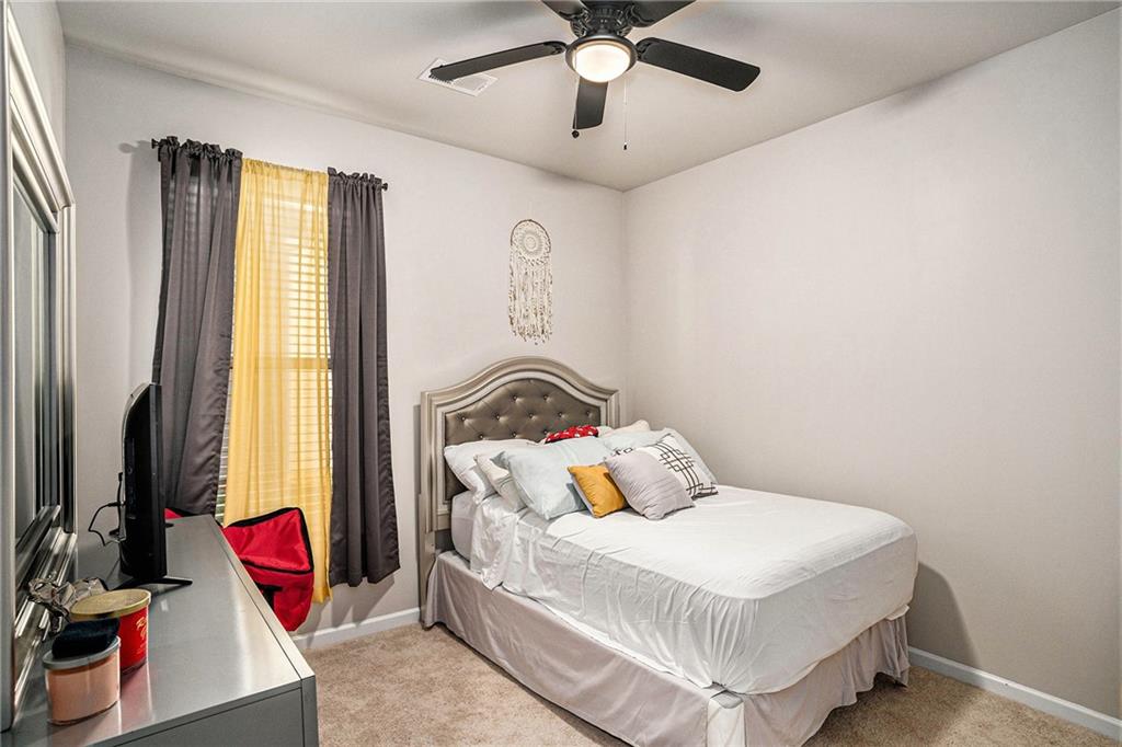 11940 Brightside Parkway Hampton, GA 30228 - Photo 26 of 31 a bedroom with a bed and wooden floor