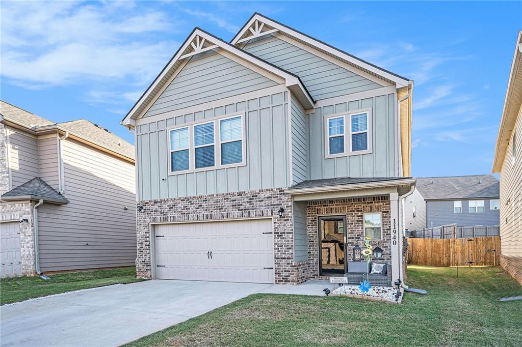 11940 Brightside Parkway Hampton, GA 30228 - Photo 3 of 31 a view of a house with brick walls and a yard with a large tree