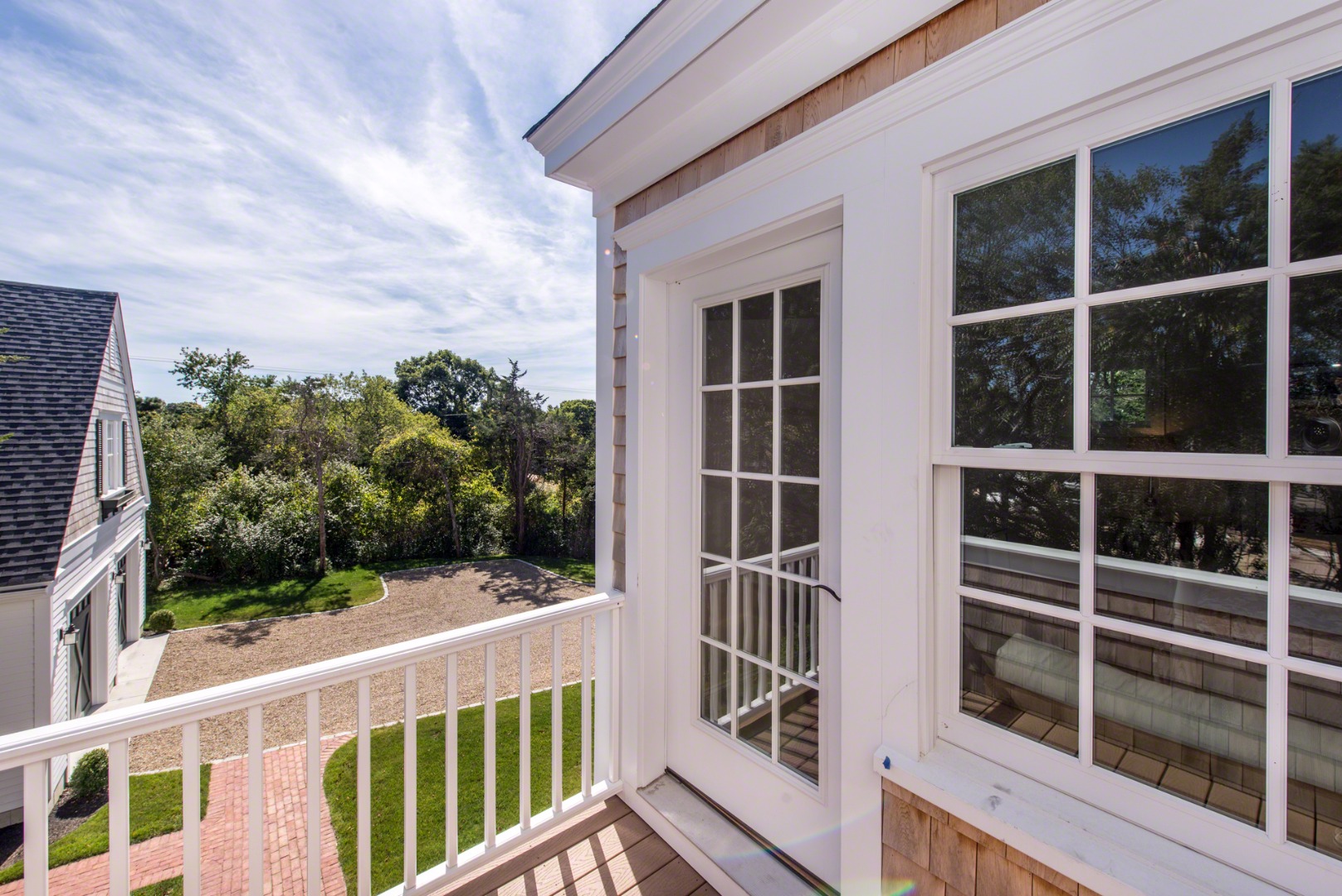 61 Clevelandtown Road Edgartown, MA 02539 - Photo 25 of 43 a view of a balcony with a floor to ceiling window and wooden fence