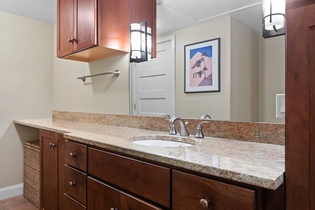 a bathroom with a granite countertop sink a mirror and vanity