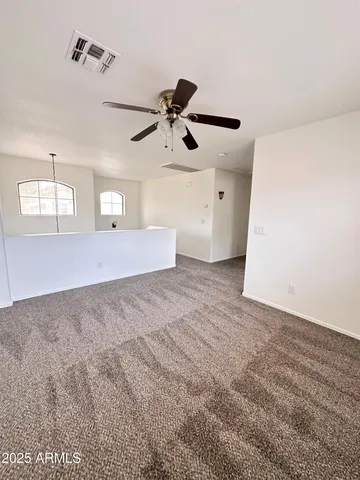 an empty room with windows and fan