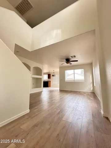 a view of a hallway with wooden floor and windows