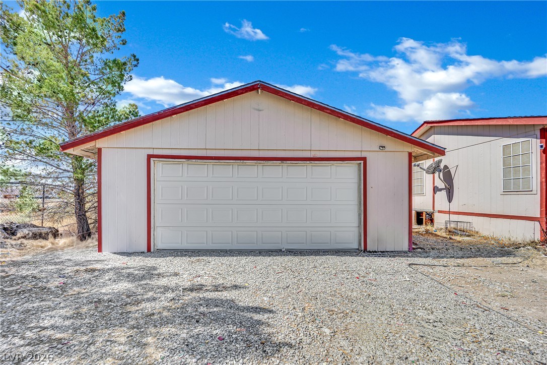 4361 Maple Road Pahrump, NV 89048 - Photo 40 of 46 Secure parking solutions with this detached garage featuring a wide door and easy-access gravel driveway.