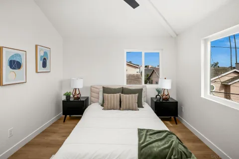 a bedroom with a bed and painting on the wall