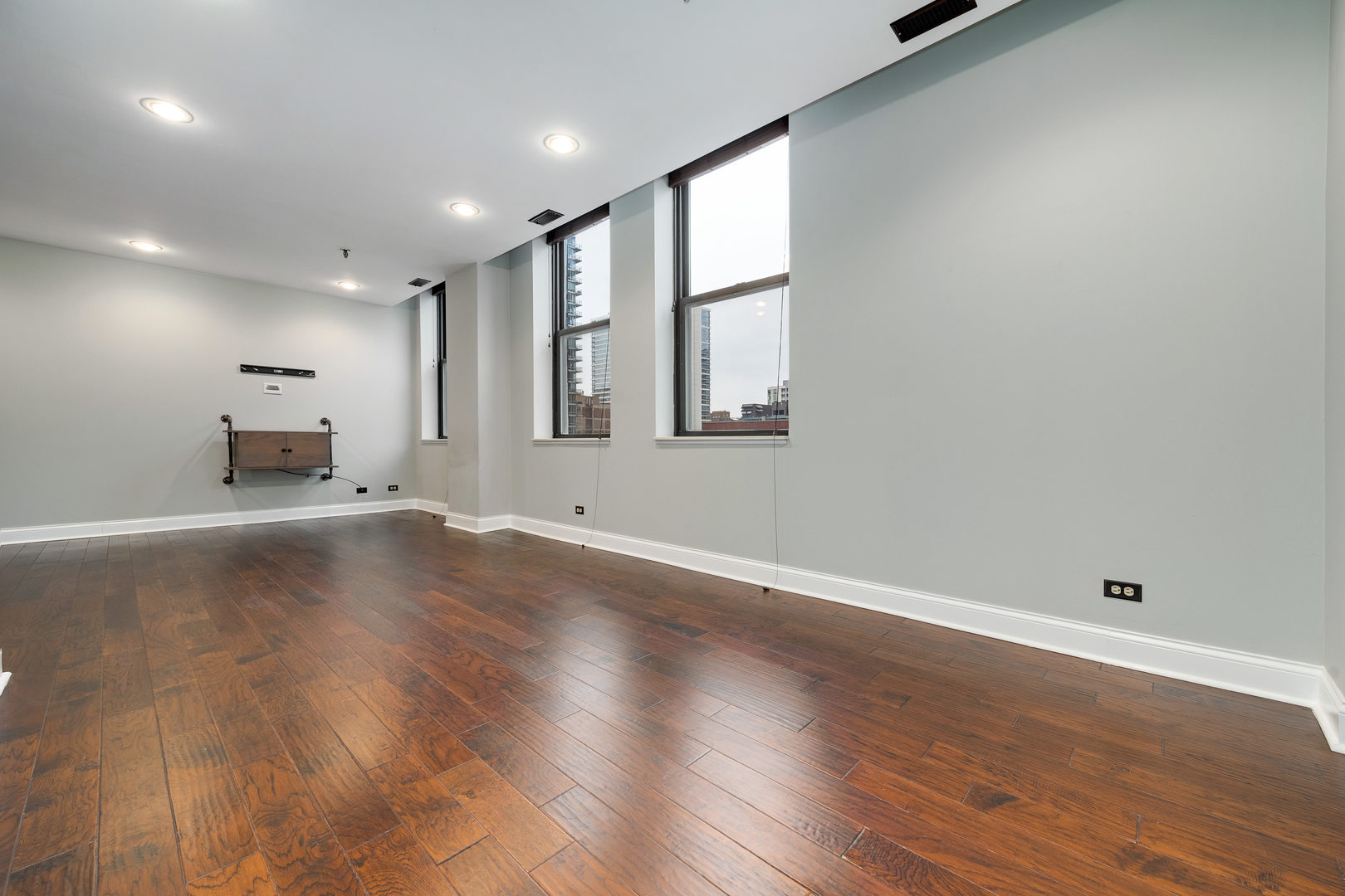 640 South Federal Street, Unit 708 Chicago, IL 60605 - Photo 7 of 20 an empty room with wooden floor and windows