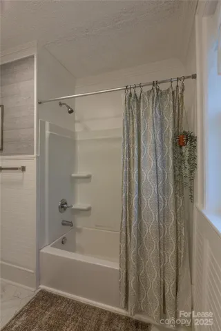 a bathroom with a shower curtain and a bathtub