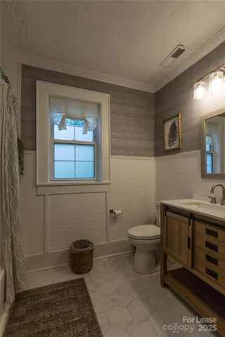 a bathroom with a toilet a sink and mirror
