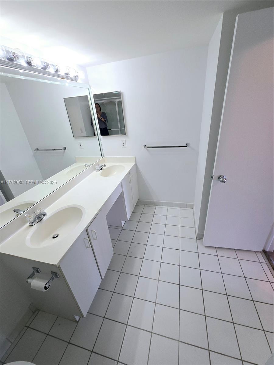 3300 Northeast 191st Street, Unit 609 Aventura, FL 33180 - Photo 13 of 16 a bathroom with a sink and mirror
