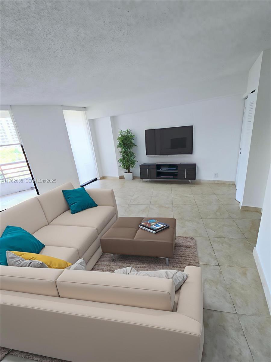 3300 Northeast 191st Street, Unit 609 Aventura, FL 33180 - Photo 5 of 16 a living room with furniture and a flat screen tv