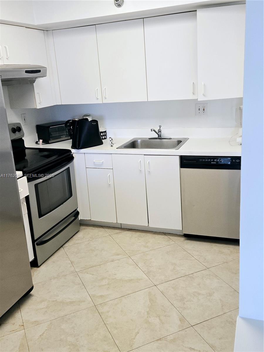 3300 Northeast 191st Street, Unit 609 Aventura, FL 33180 - Photo 6 of 16 a kitchen with cabinets and appliances