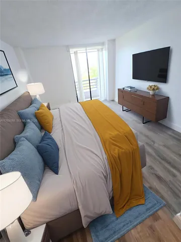a bedroom with a bed and flat screen tv